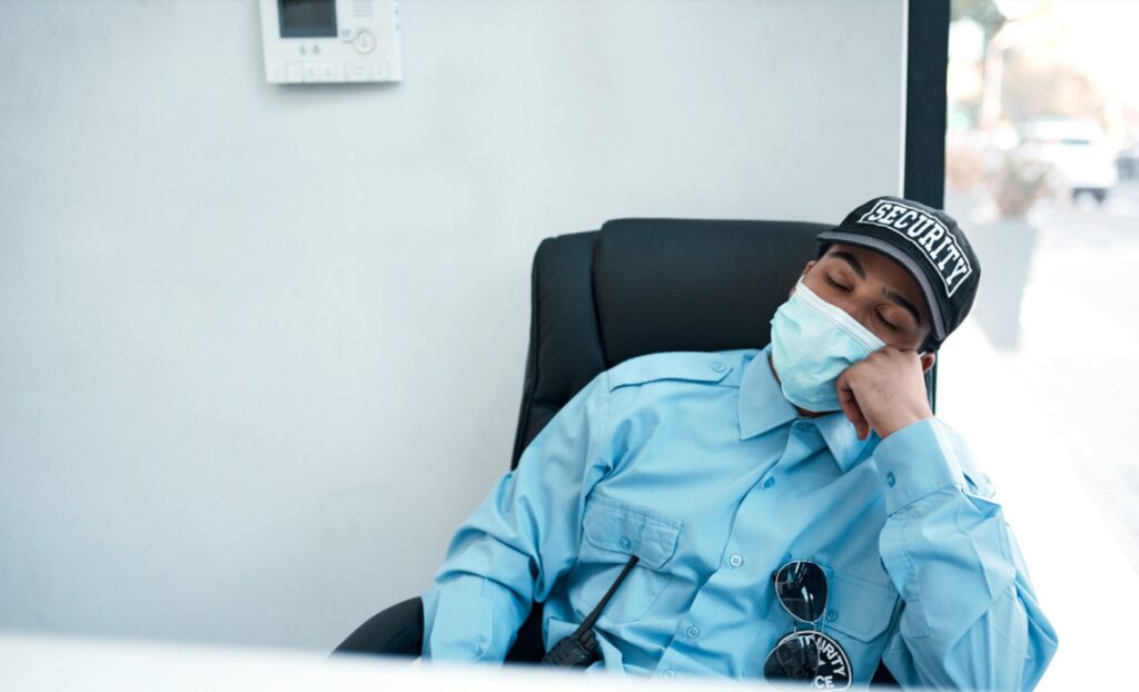 A Security Guard Sleeping At His Desk