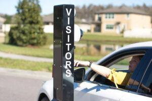 A woman in a car pulling up to a Virtual Gate Guard